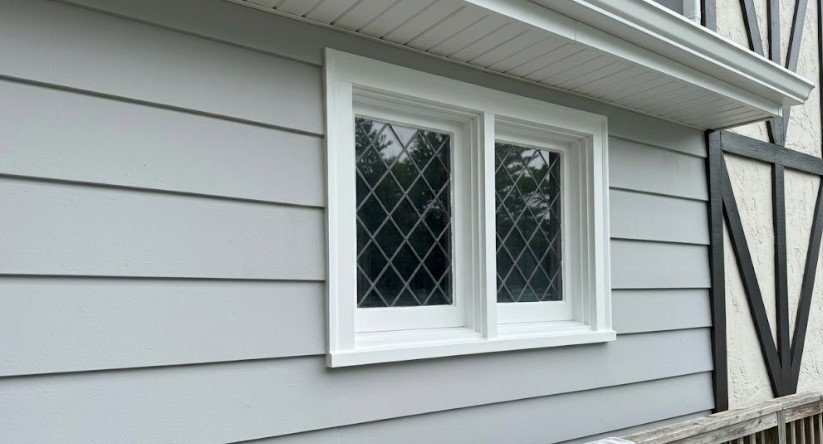 The same gray siding clean and repainted, with fresh white window trim and no mildew streaks