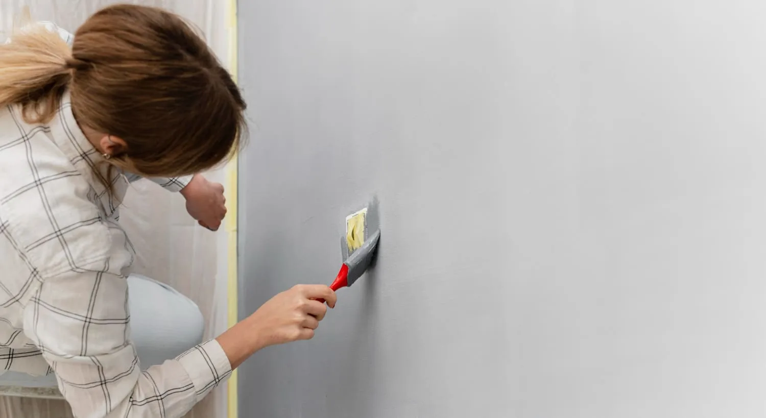 a woman painting a wall