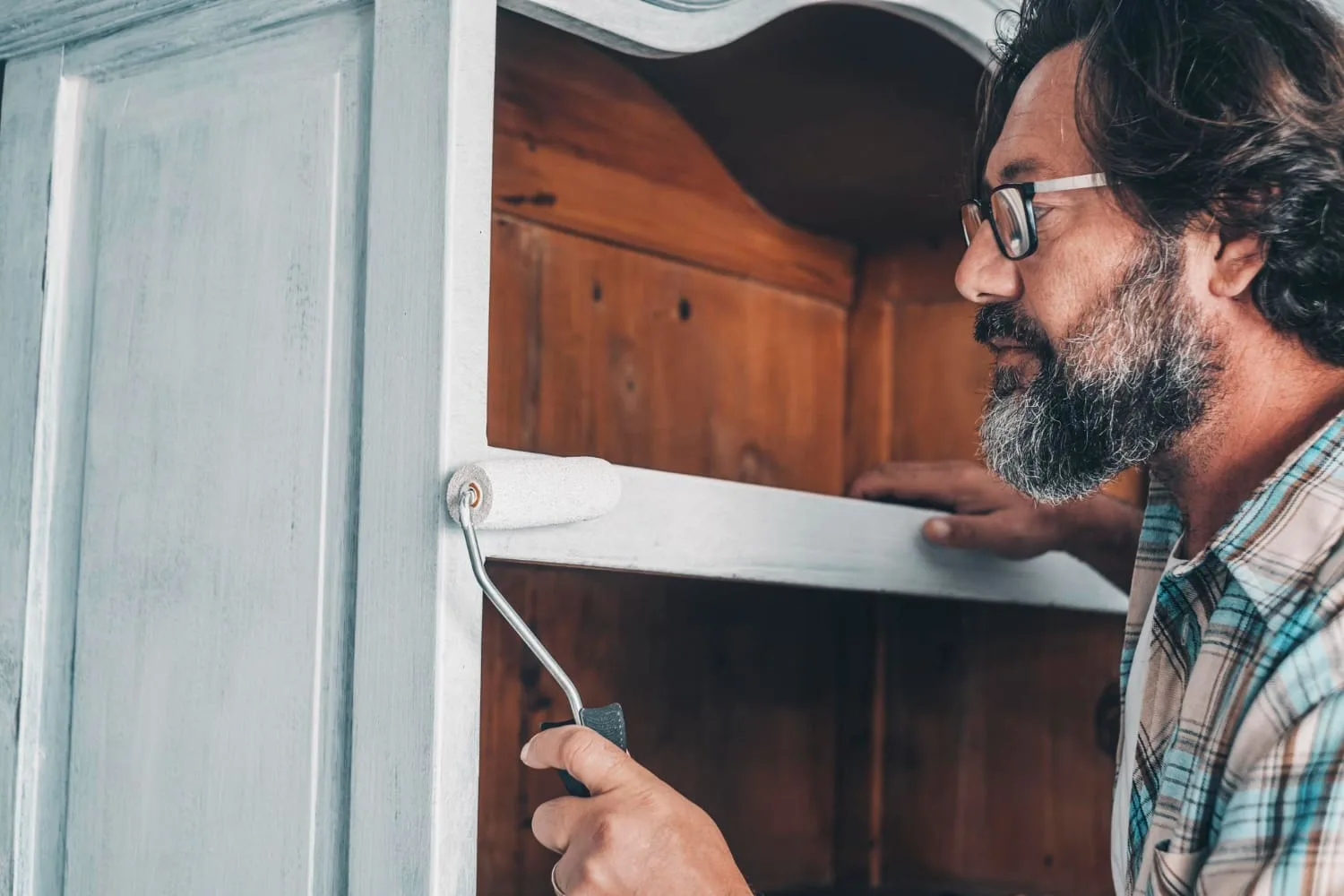 a man painting a shelf