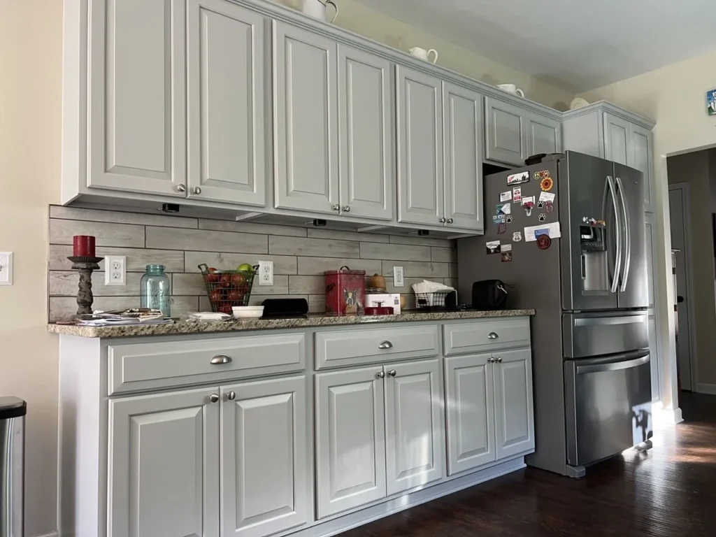 a kitchen with white cabinets and a stainless steel refrigerator