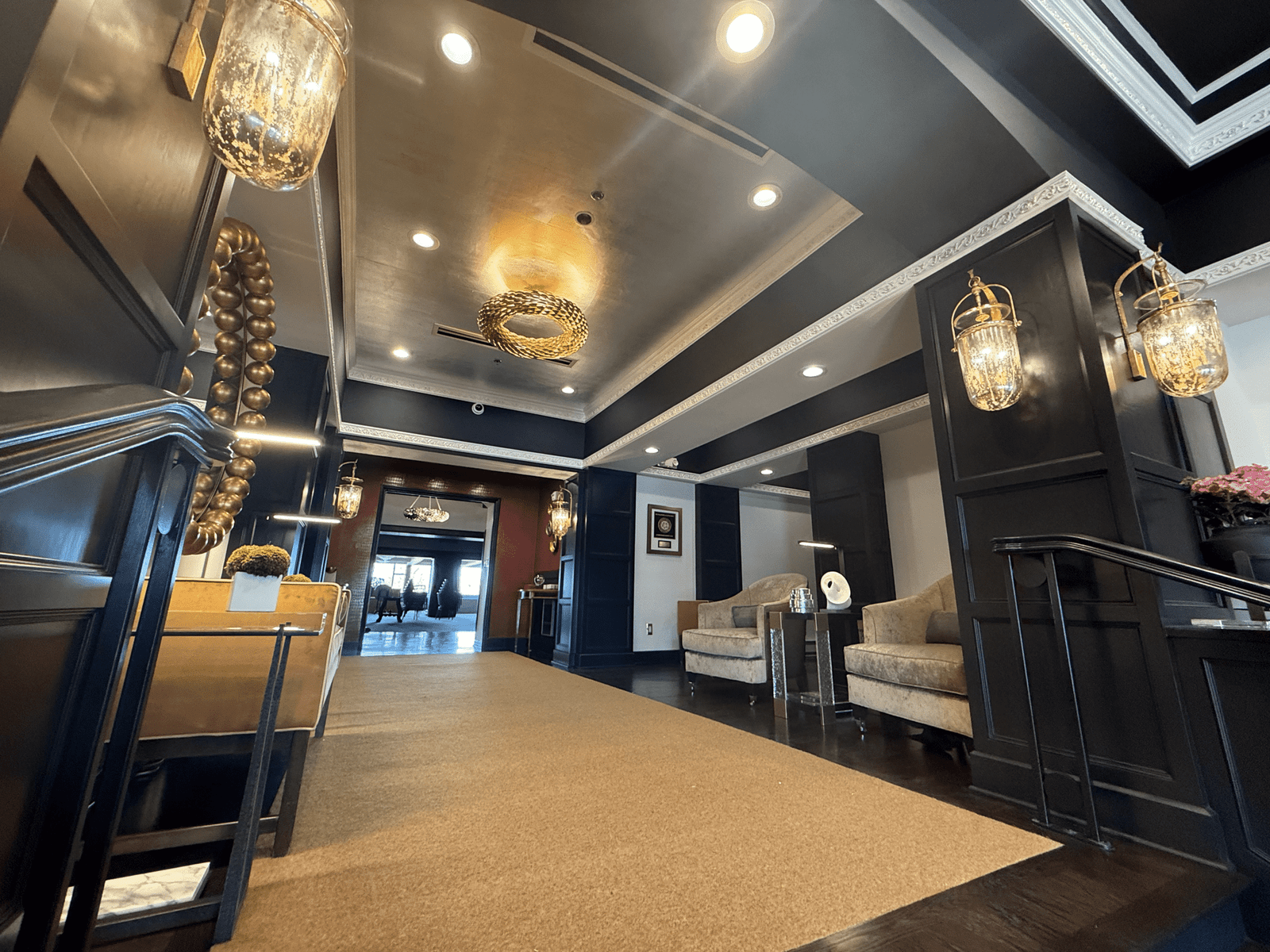 a hallway with a large chandelier and a couch