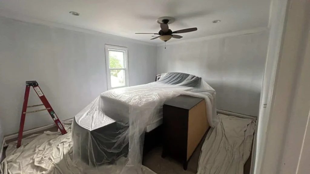 How to Deal with Paint Peeling Off Wall: Causes and Solutions 7 a bed covered in plastic