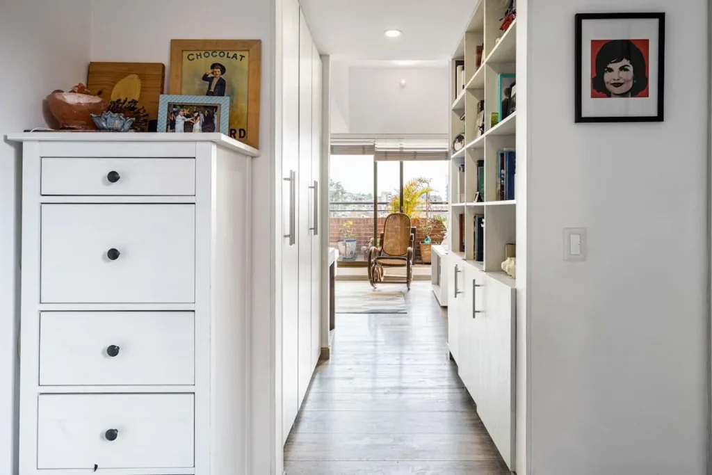 a hallway with white cabinets and shelves